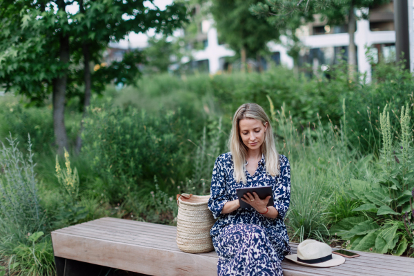 Mature woman sitting in a park bench, enjoying time for herself.