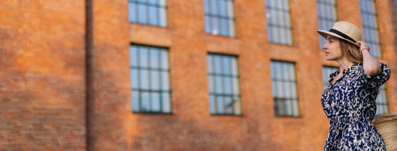 Young woman in a city during sunset. Wide photography.