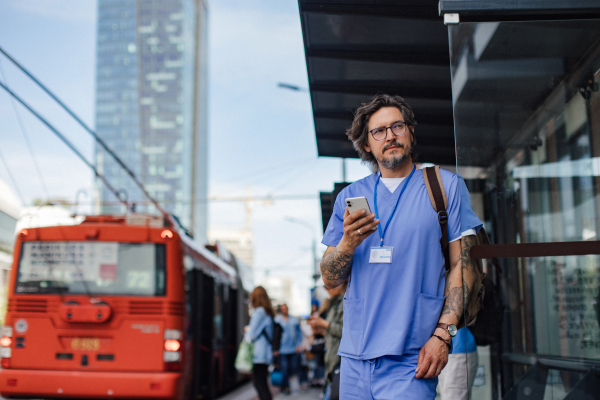 Doctor wating foth the bus at bus stop, going home from a work. Work-life balance of healthcare worker.