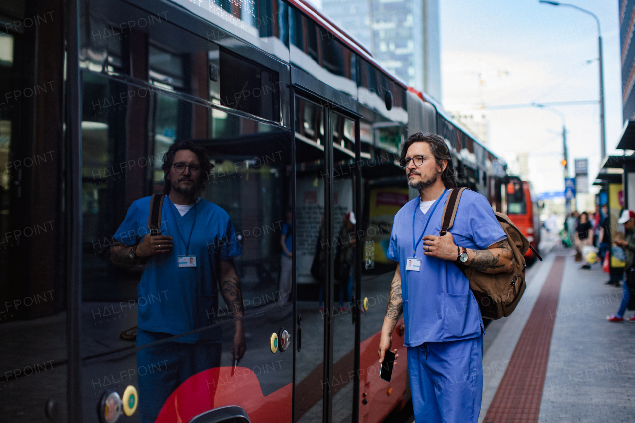 Doctor wating foth the bus at bus stop, going home from a work. Work-life balance of healthcare worker.