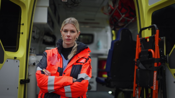 Video of a young woman doctor standing in front of ambulance car.