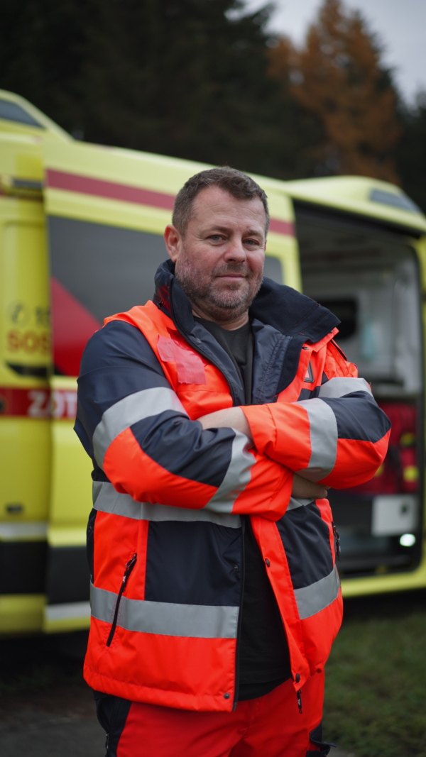 Vertical video of a man doctor standing in front of ambulance car.