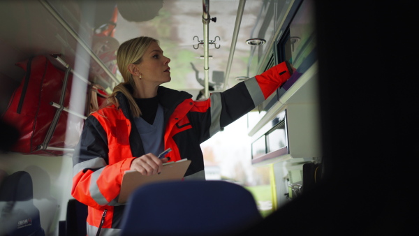 Video of woman rescuer preparing in ambulance car to outdoor operation.