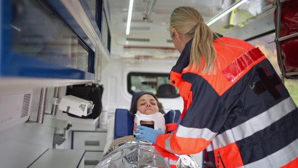 Rescuer taking care of a patient, preparing her for transport.