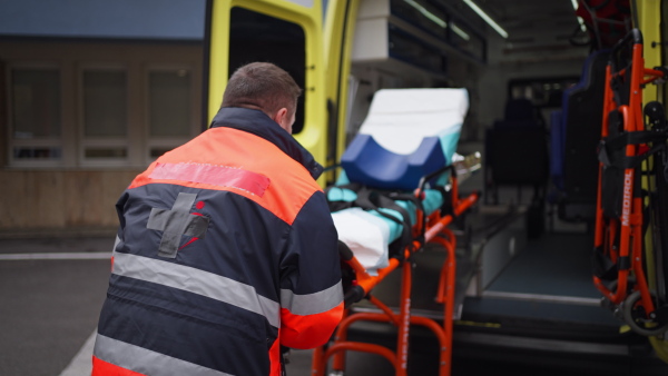 Video of rescuer getting empty stretcher inside ambulance vehicle.