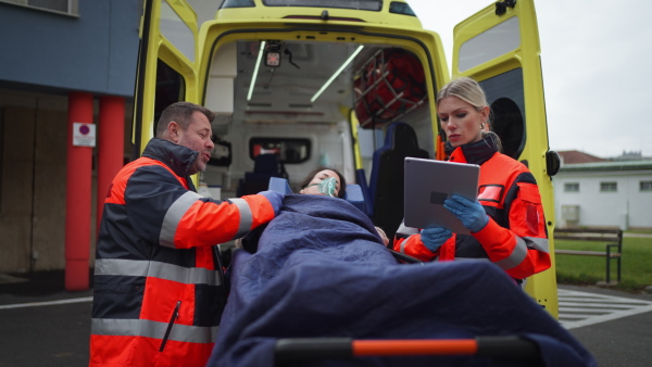 Rescuers taking care of a patient, preparing her for transport.