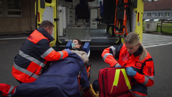 Rescuers taking care of a patient, preparing her for transport.