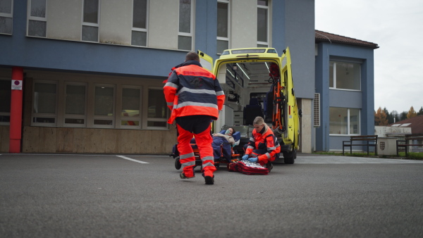 Rescuers taking care of a patient, preparing her for transport.