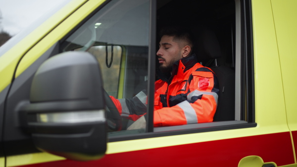 Video of young man doctor sitting in the ambulance car.