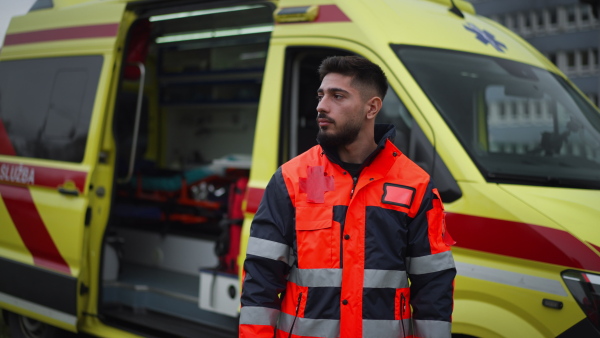 Video of a young man doctor standing in front of ambulance car.