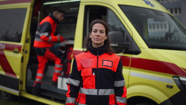 Video of a young woman doctor standing in front of ambulance car.