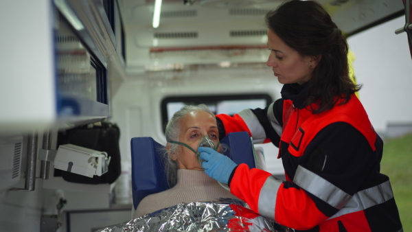 Rescuer taking care of a patient, preparing her for transport.