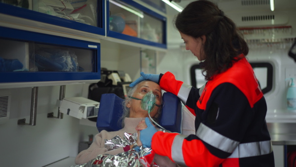 Rescuer taking care of a patient, preparing her for transport.