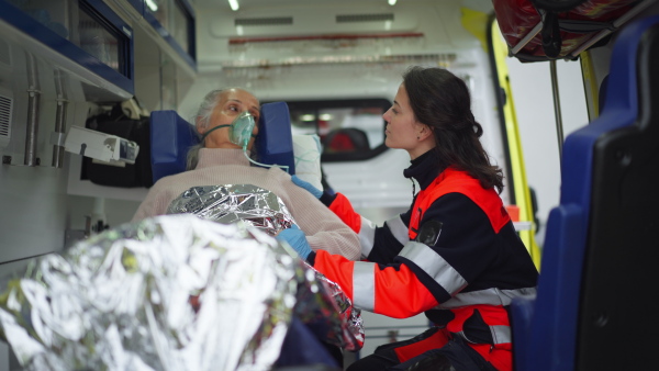 Rescuer taking care of a patient, preparing her for transport.