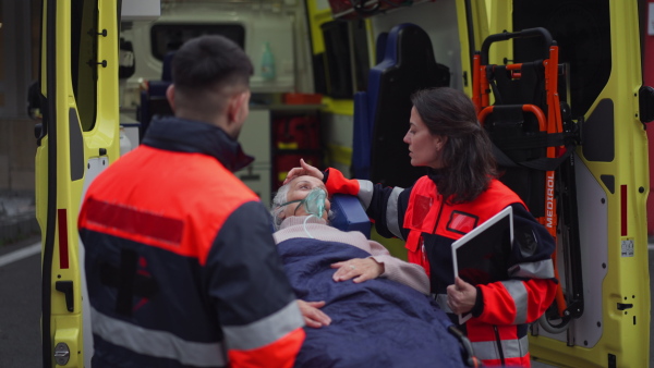 Rescuers taking care of a patient, preparing her for transport.