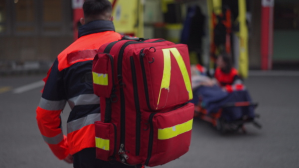 Rescuers taking care of a patient, preparing her for transport.