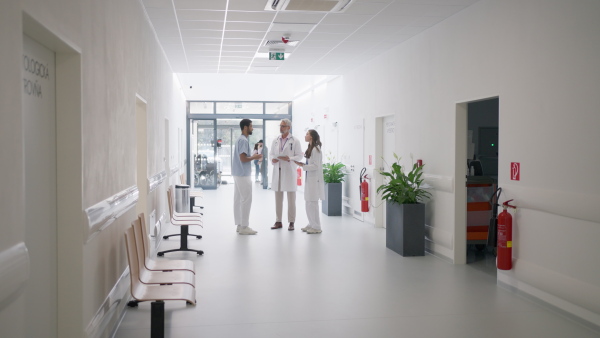 Team of doctors discusing at a hospital corridor.