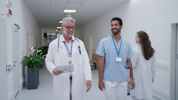 Team of doctors greeting at a hospital corridor.