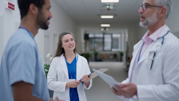 Team of doctors talking at a hospital corridor.