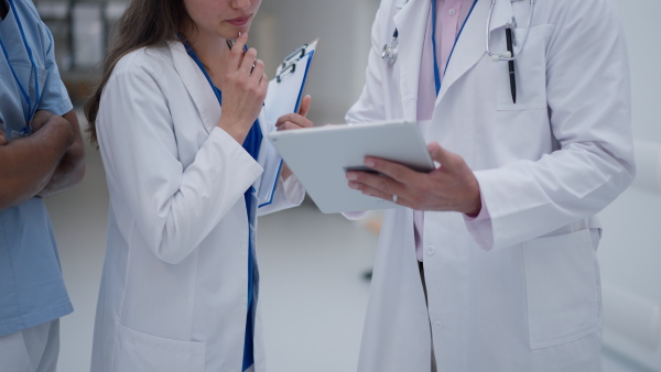 Close-up of team of doctors meeting at a hospital corridor.