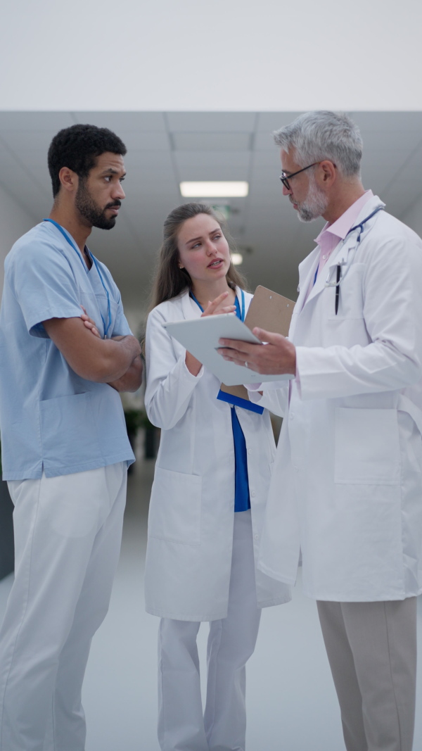 Doctors discussing something at a hospital corridor, vertical footage.