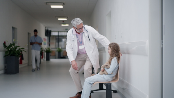 Doctor talkingwith his little patient at pediatrics corridor.