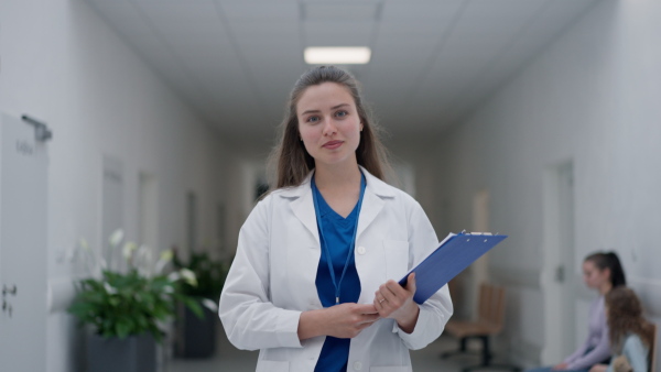 Young woman doctor walking on a hospital corridor.