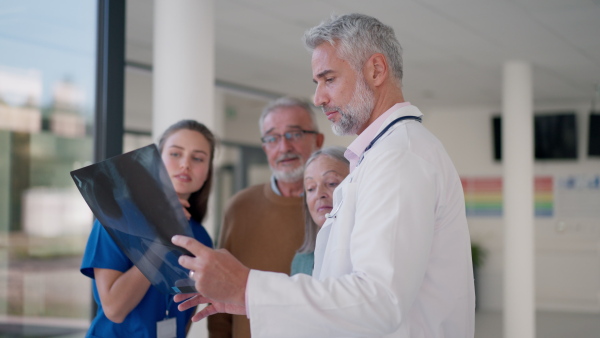 Doctor showing x-ray image to patients, explaining a diagnosis.