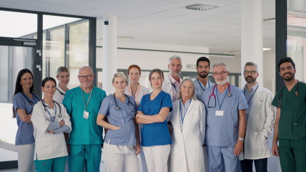 Happy doctors, nurses and other medical staff posing in a hospital.