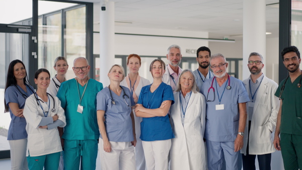 Happy doctors, nurses and other medical staff posing in a hospital.