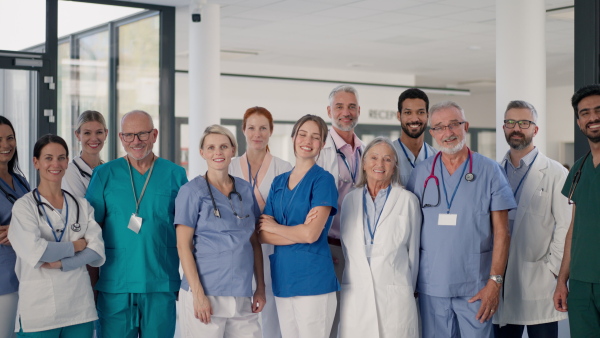 Happy doctors, nurses and other medical staff posing in a hospital.