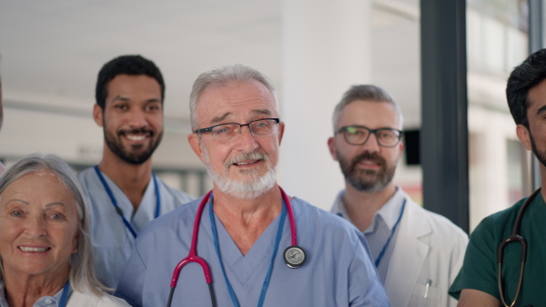 Happy doctors, nurses and other medical staff posing in a hospital.