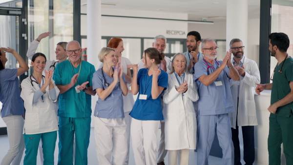 Happy doctors, nurses and other medical staff posing in a hospital.