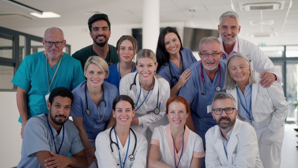 Happy doctors, nurses and other medical staff posing in a hospital.