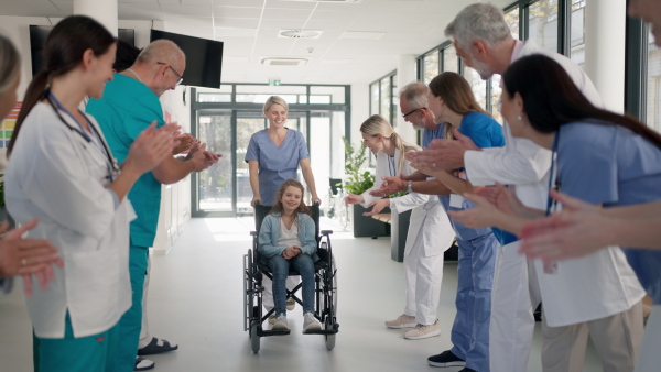 Medical staff clapping to patient who recovered from a serious illness.