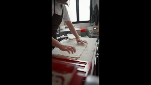 Video of young baker preparing pastries in a bakery.