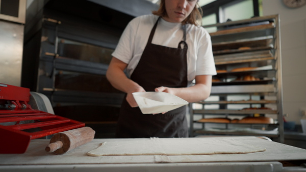 Video of young baker preparing pastries in a bakery.