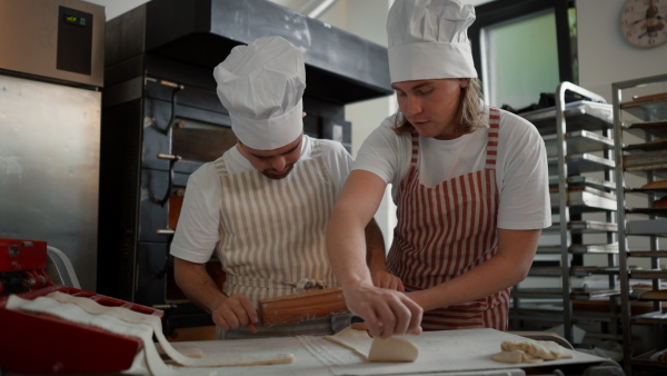 Video of a man with down syndrom helping prepair bread in a bakery with his colleague. Concept of integration people with disability into society.