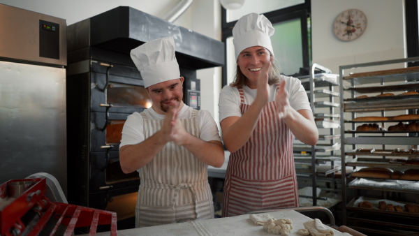 Video of man with down syndrom and his colleague in a bakery. Concept of integration people with disability into society.