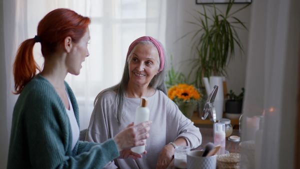 Caregiver helping her senior client with a make up.