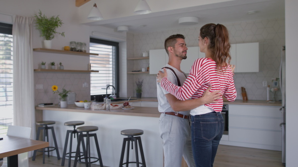 Young attractive couple dancing in the kitchen of new home.