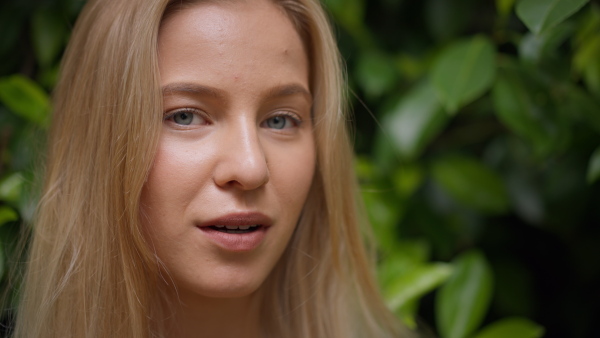 A tennager girl looking at camera in forest, close-up