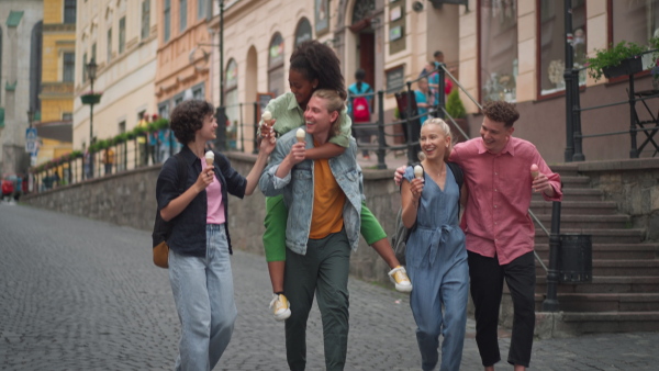 Group of friends enjoying nice time together in town, having an ice cream. Holiday concept.