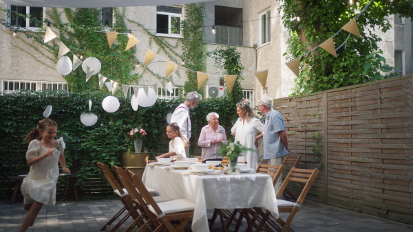 Little child running and enjoying an outdoor wedding party of her parents.