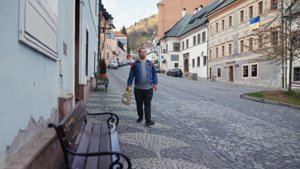 An independent young man with Down syndrome going back from gocery store with purchase.