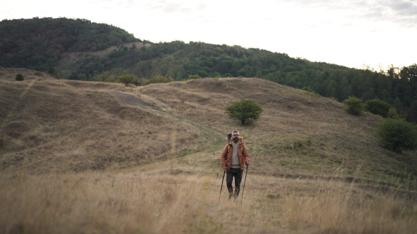 Male hiker walking alone in nature. Minimal full lenght shot.