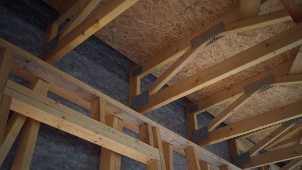 Sliding shot of wooden frame roof of sustainable house construction.