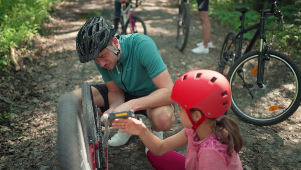 A young family with little children on a ride father reparing a bike.