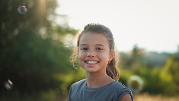 A video of a beautiful little girl laughing when having fun in summer in nature.