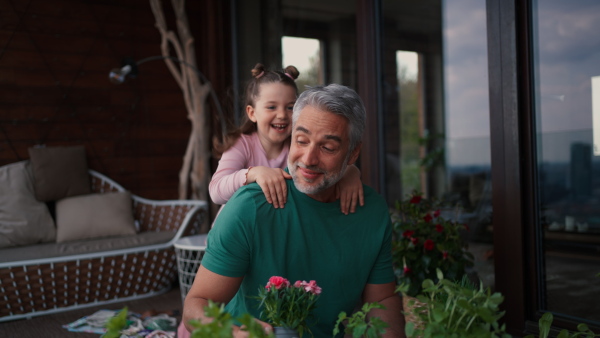 A little cute daughter hugging her happy father at home.